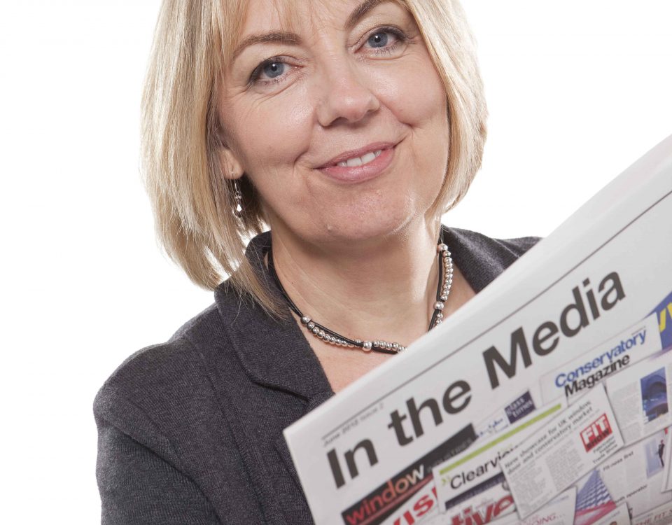 Amanda holding a newspaper called 'in the media'