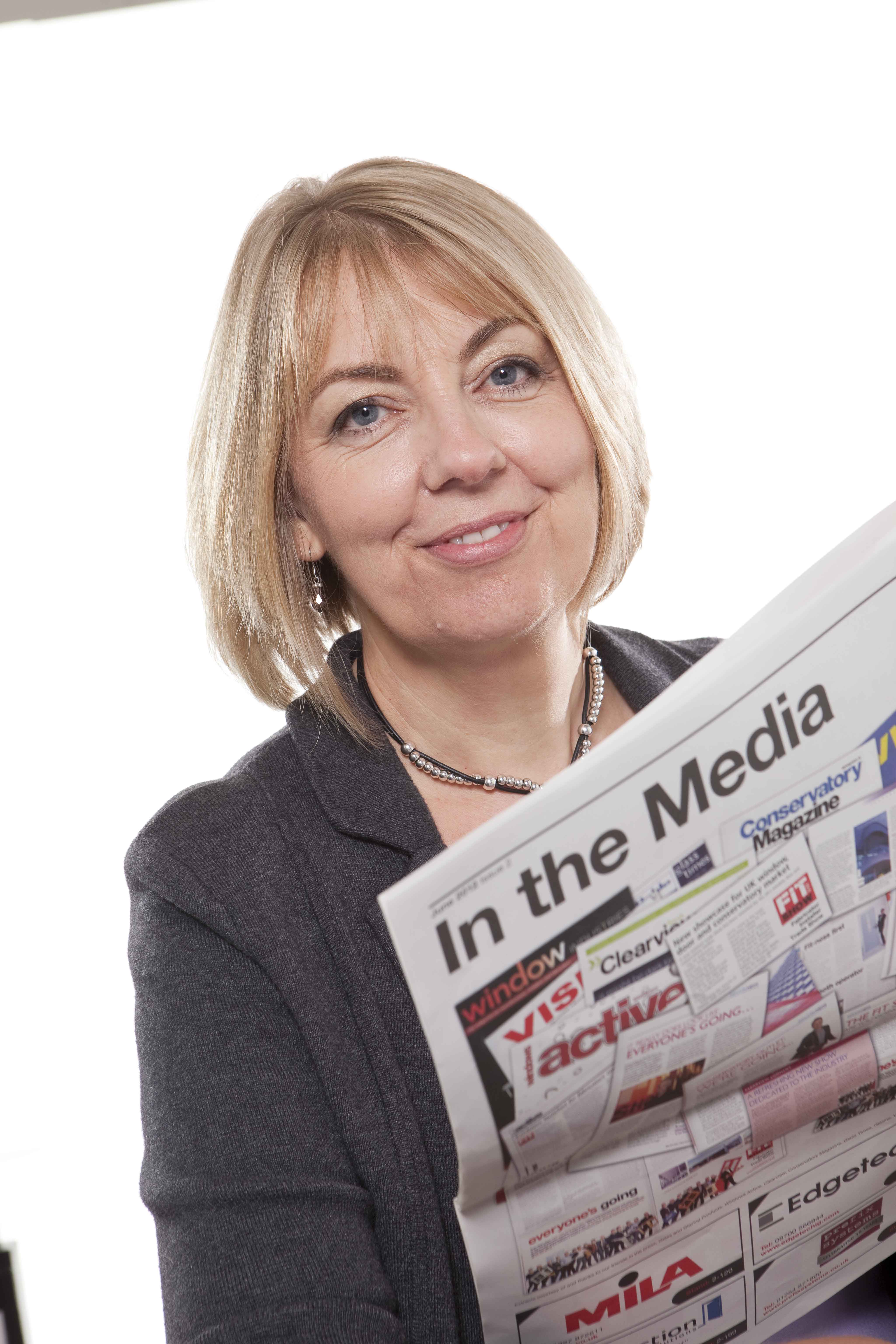 Amanda holding a newspaper called 'in the media'